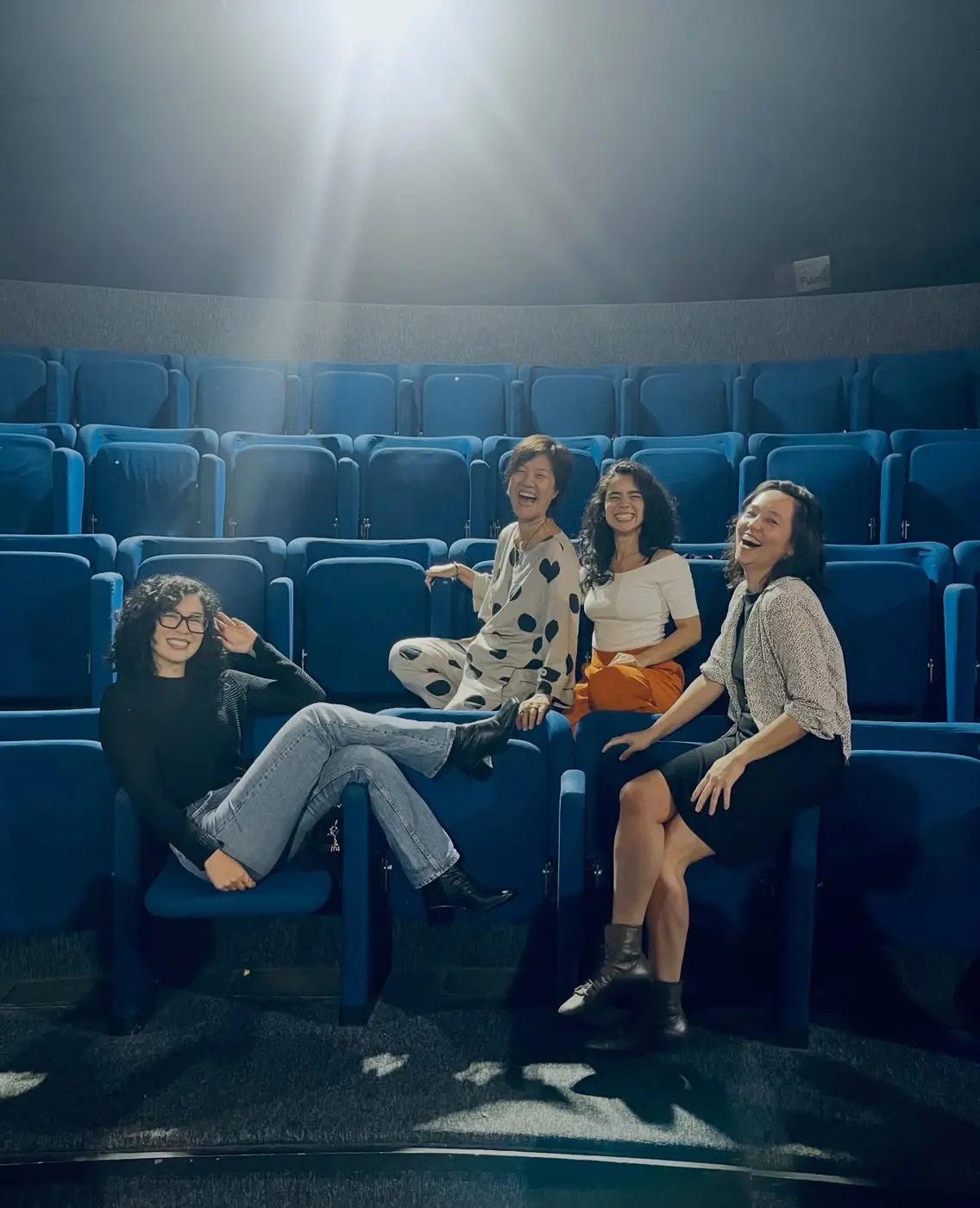Grupo de artistas reunidas em uma sala de cinema